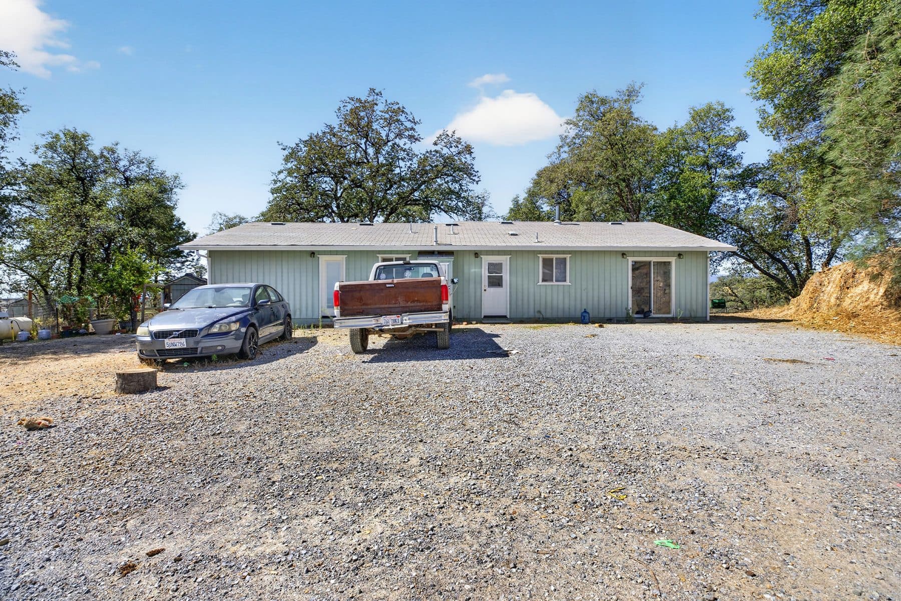 Gravel driveway at a Creek Trail home in Redding with two vehicles parked out front